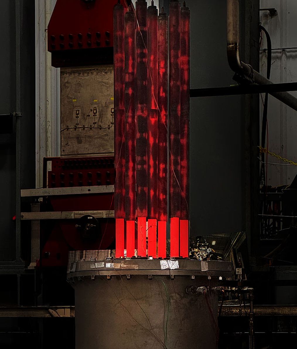 A bundle of heat pipes glowing red-hot above a test vessel