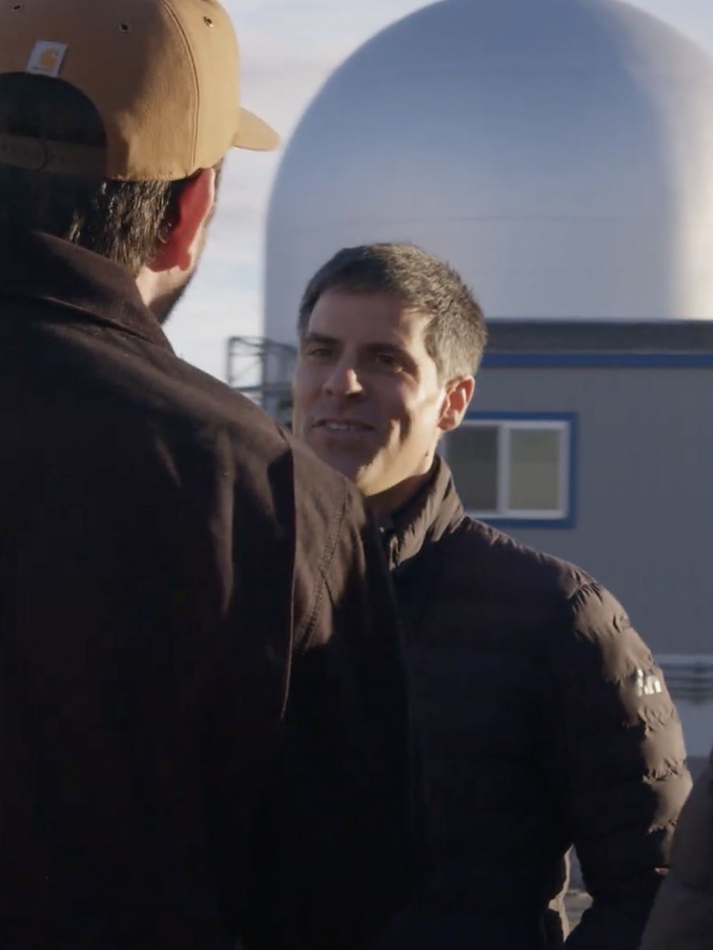 The founder talking with a colleague outside the reactor dome