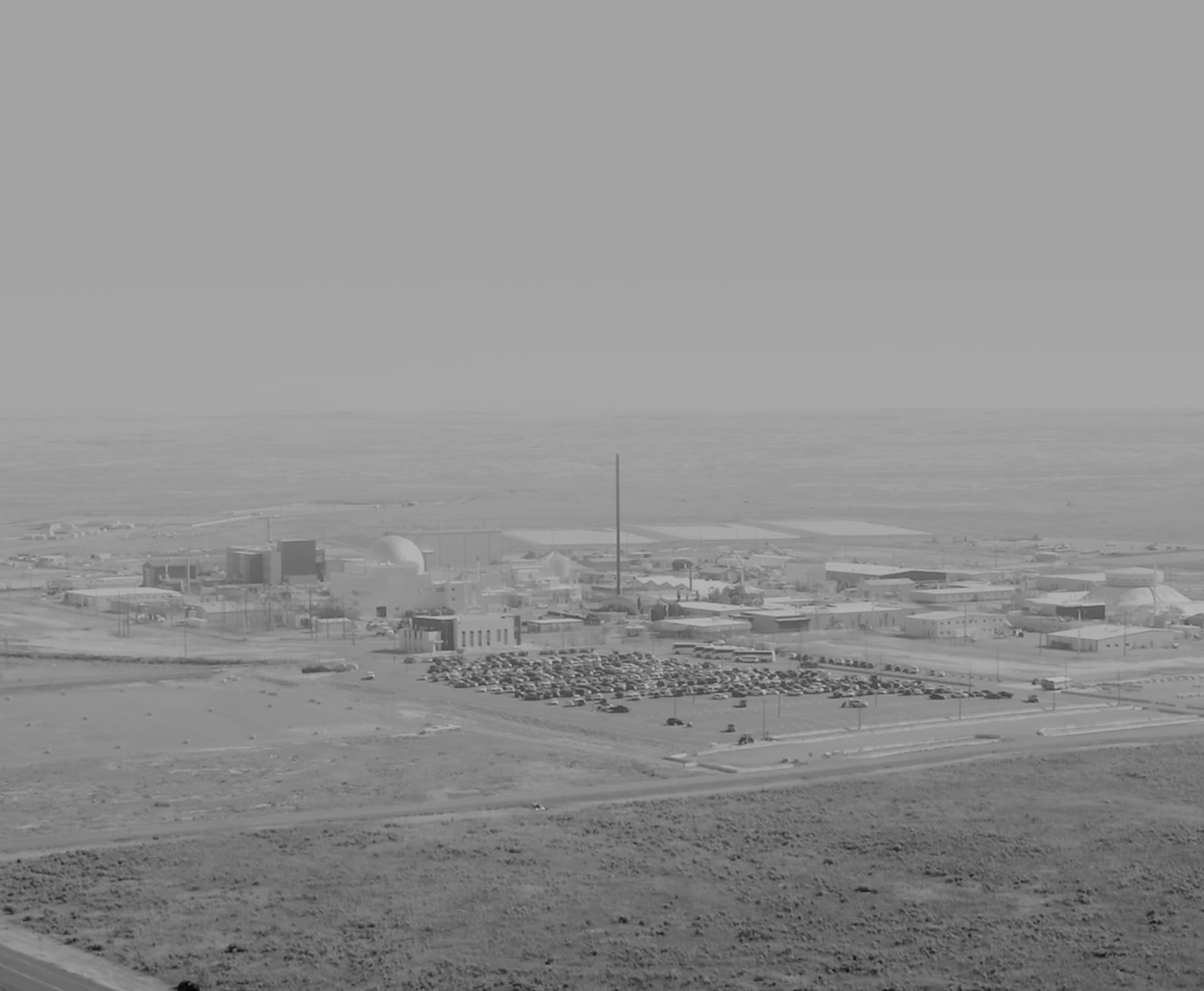 Hazy aerial view of a reactor test site and its car park on open plains