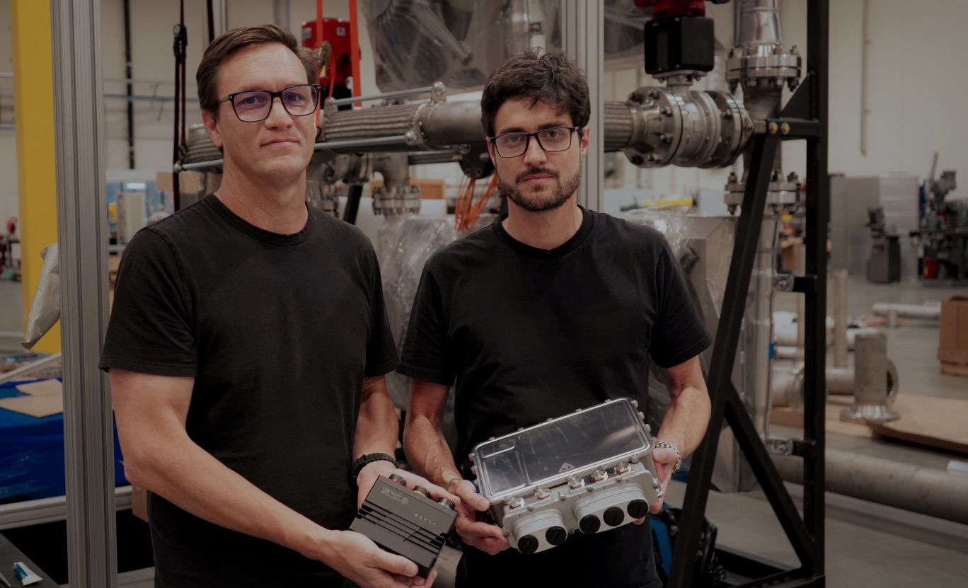 Two engineers in the lab, each holding a piece of reactor hardware